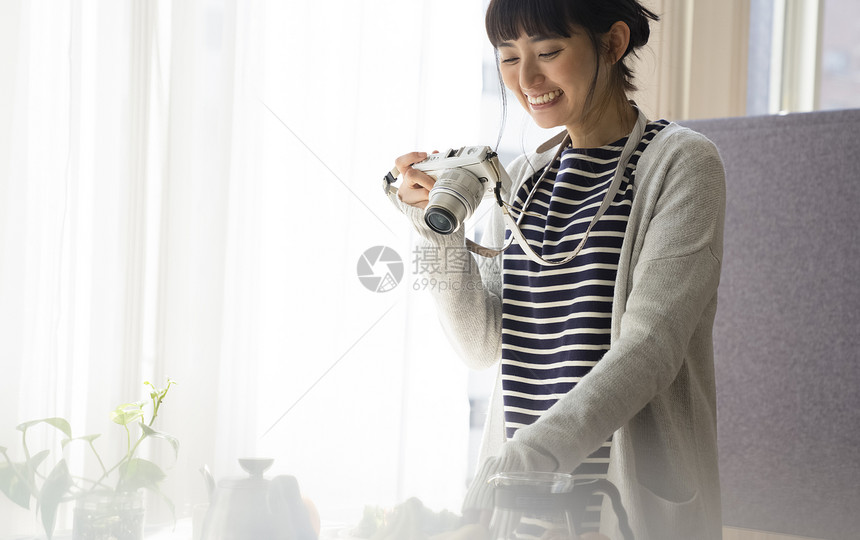 年轻女子开心的拿着相机图片