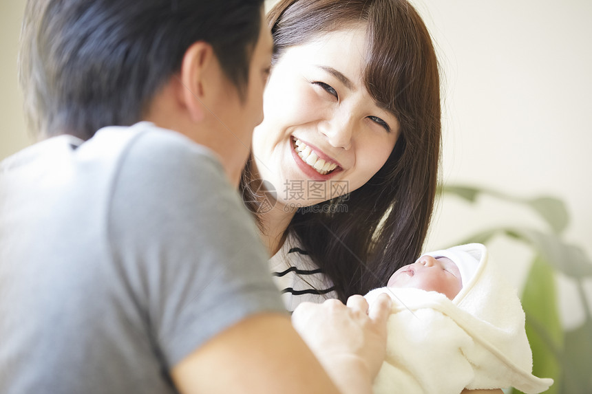 年轻夫妇在照看初生婴儿图片