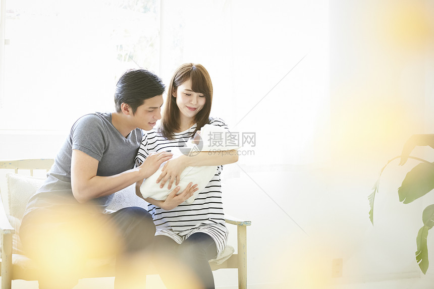 年轻夫妇在照看初生婴儿图片