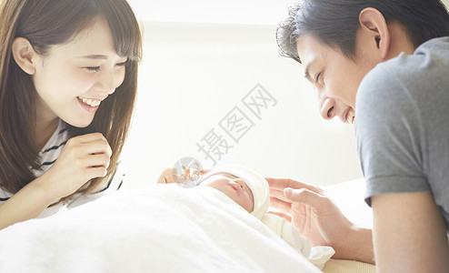 年轻夫妇在照看初生婴儿背景图片