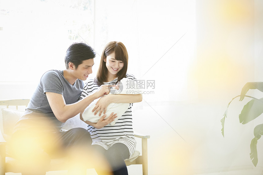 年轻夫妇在照看初生婴儿图片