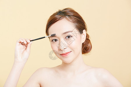 眉毛透明素材使用眉刷化妆的成年女性背景