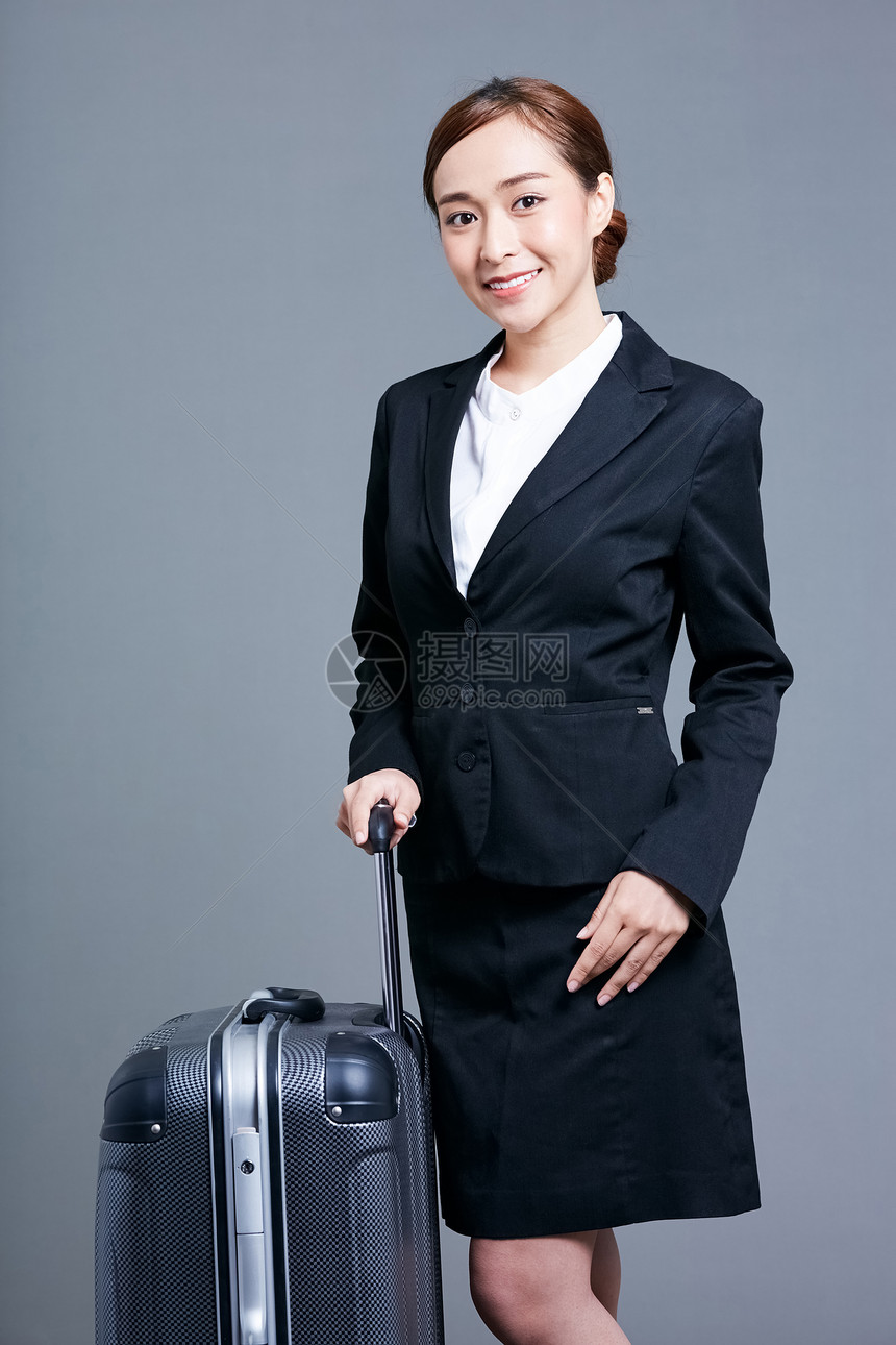 穿着职业套装托着行李箱的商业女强人图片