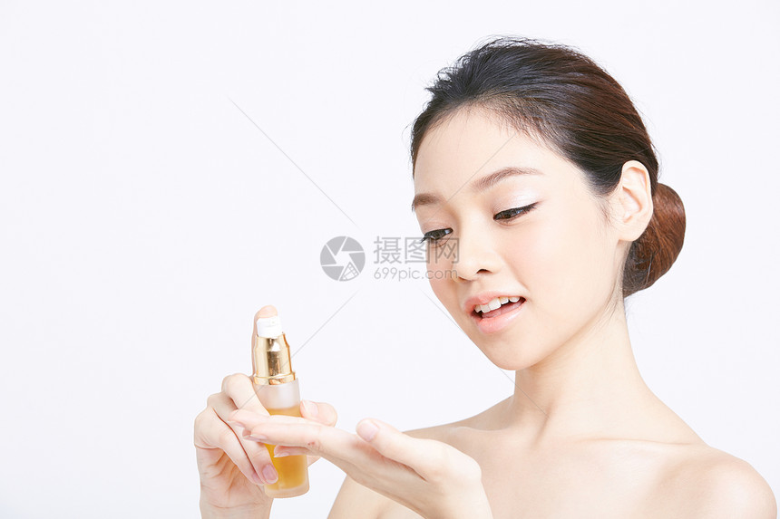 按压使用化妆品的年轻女子图片