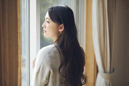 在窗户旁的年轻女人图片