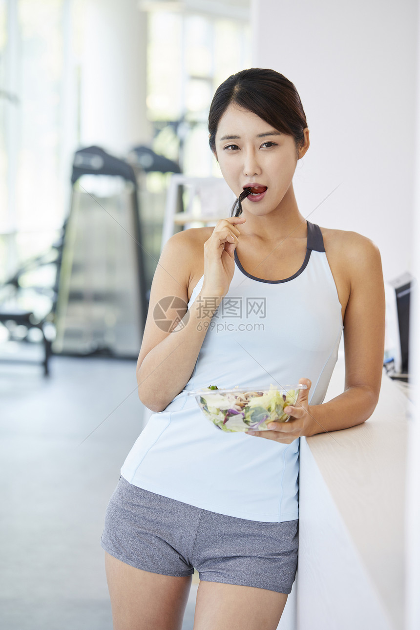 健身房吃健康沙拉的女人图片