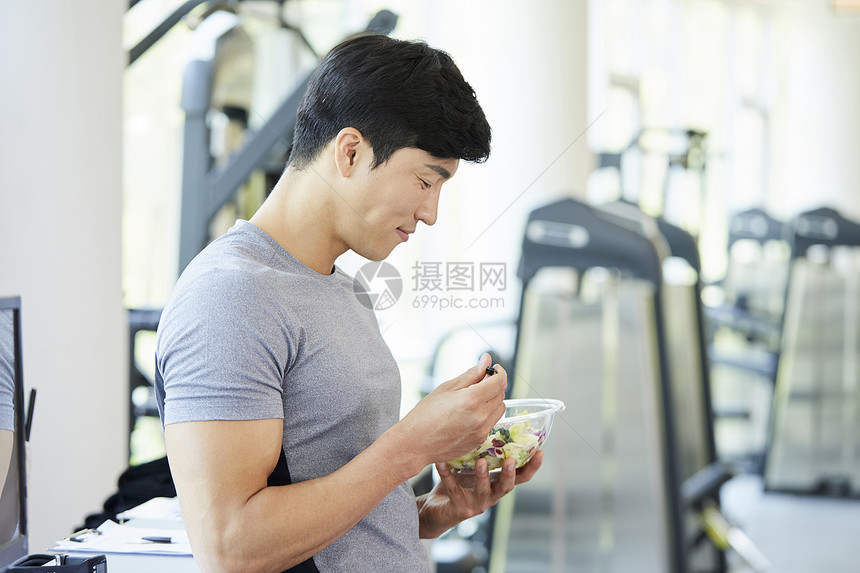 健身房的年轻男子吃沙拉图片