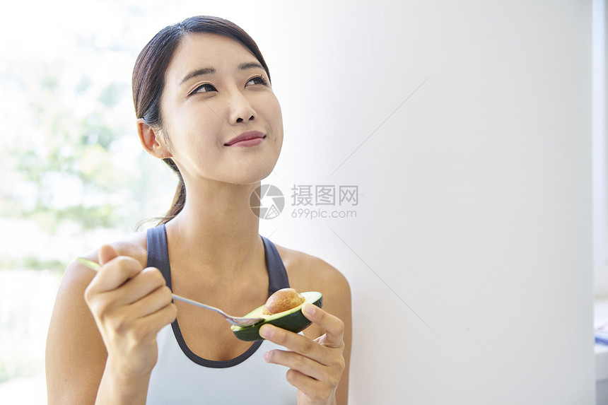 吃牛油果的健康女性肖像图片