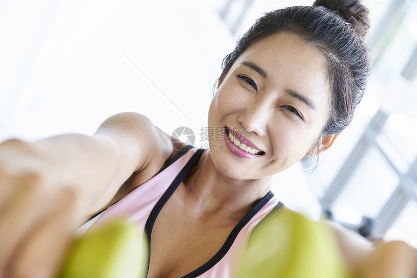 年轻女孩使用哑铃健身图片