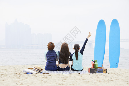 夏天沙滩上度假的少女们背影图片