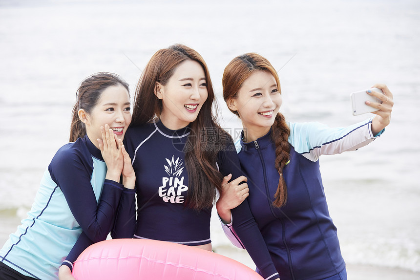 三个年轻女人在海边沙滩上自拍合影图片