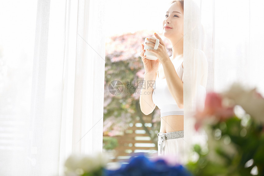 户外放松拿着咖啡的年轻女子图片