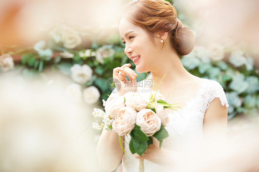花园婚礼拿着捧花微笑的新娘图片