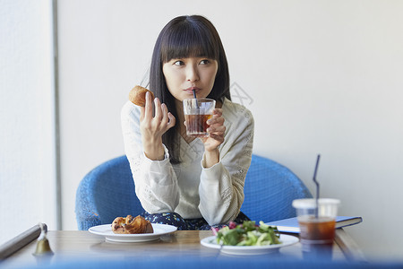 咖啡馆喝下午茶的年轻女子图片