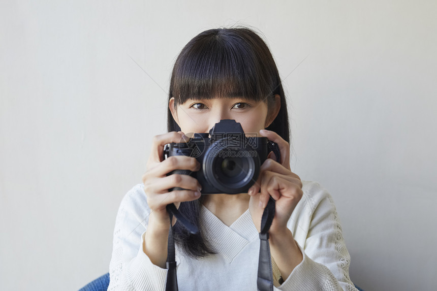 年轻女人拿着相机图片