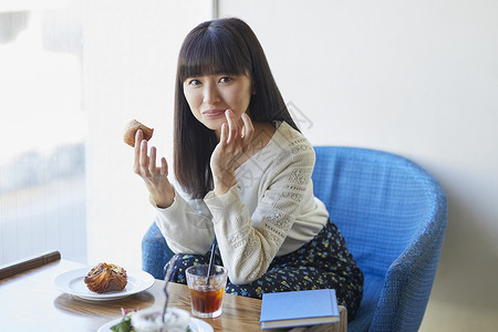 年轻女子在咖啡馆吃下午茶图片