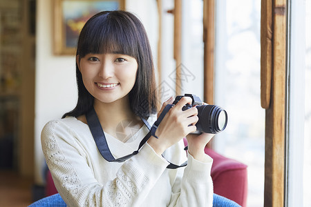 年轻女人拿着相机图片