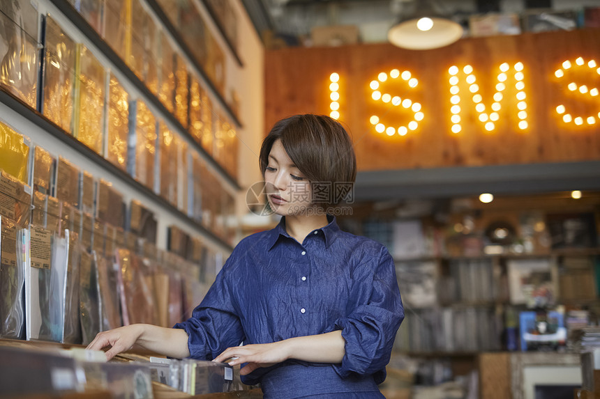 年轻美女唱片店挑选唱片图片