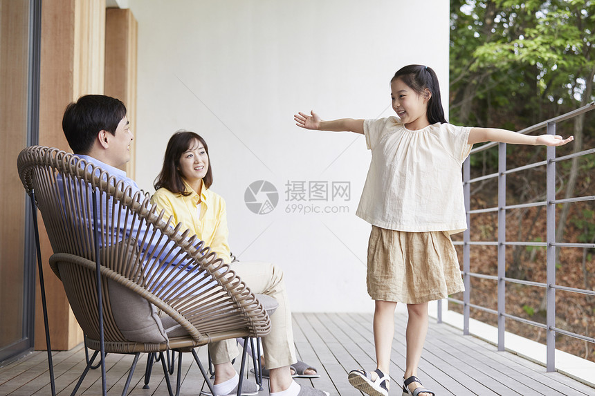 在阳台上休息玩耍的父母和女儿图片