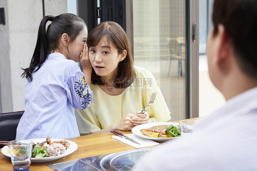 在餐桌上吃饭的父母和女儿图片