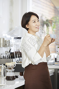 中年女性在厨房里喝咖啡图片