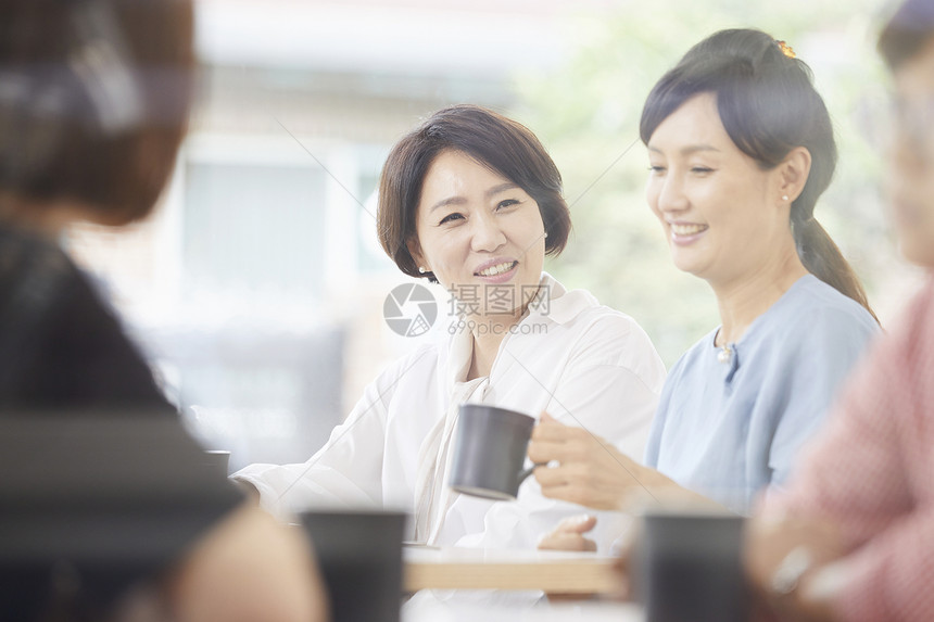 成年女子和伙伴在咖啡店享受下午茶图片