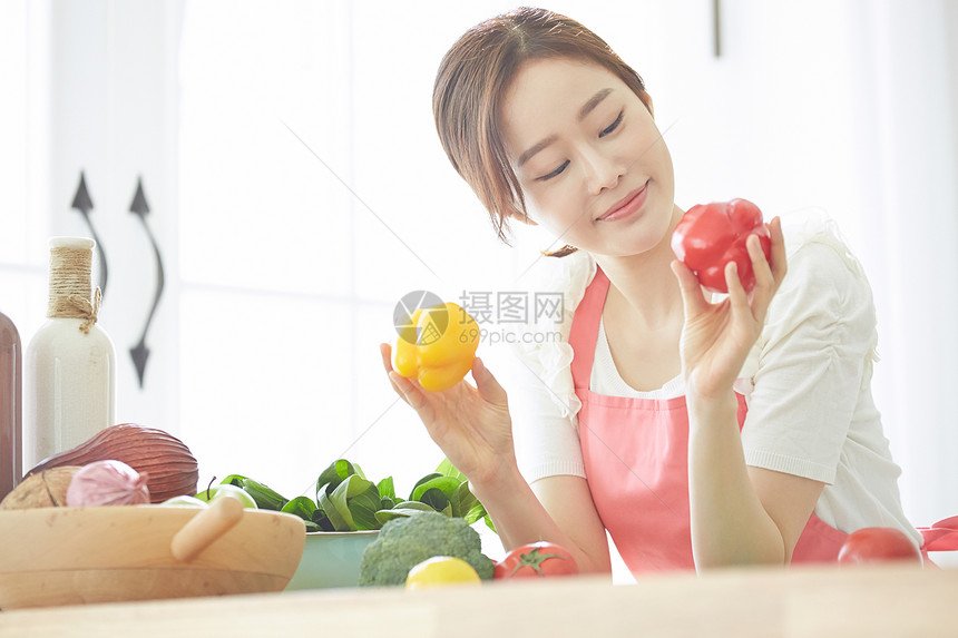 拿着彩椒微笑的女性图片