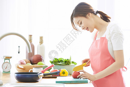 低头切蔬菜的女性图片