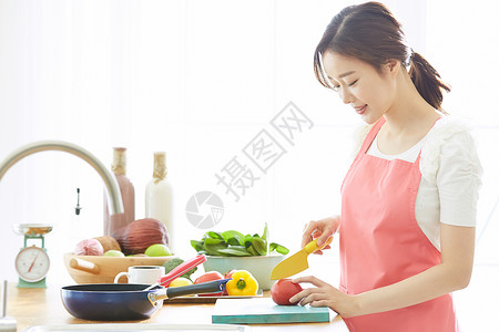 厨房里低头切蔬菜的女性图片