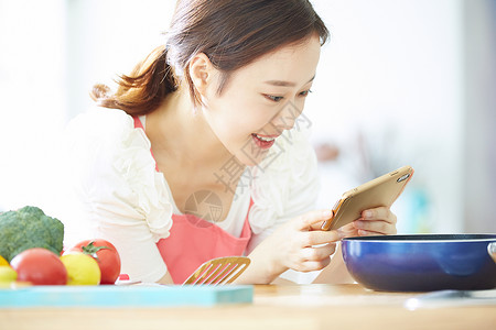 拿着手机拍食物的年轻女子图片