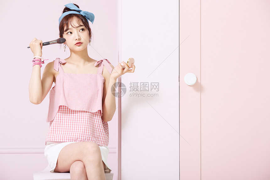 使用化妆刷的甜美少女图片