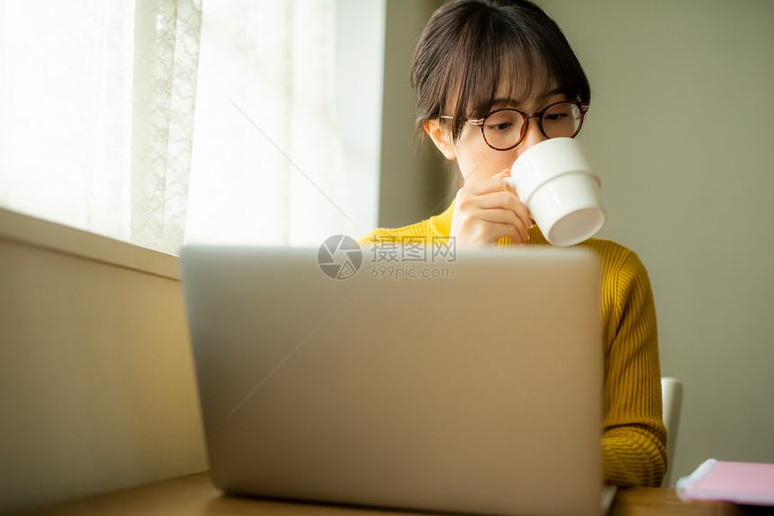 居家办公喝咖啡的年轻女性图片