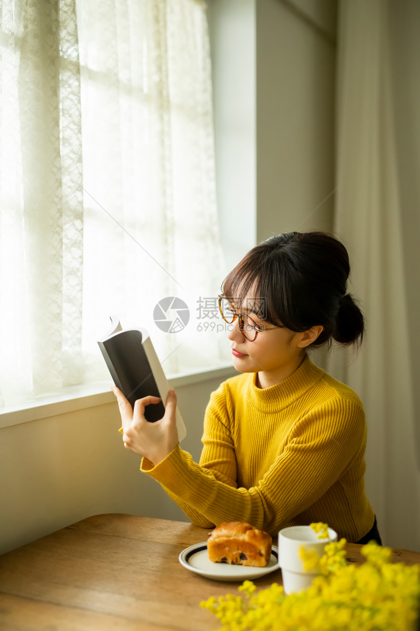 看书吃早餐的眼镜女孩图片