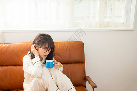 沙发上喝茶的居家女孩图片