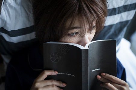 躺在床上看书的女性图片