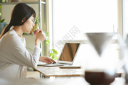 女人喝咖啡用电脑打字图片