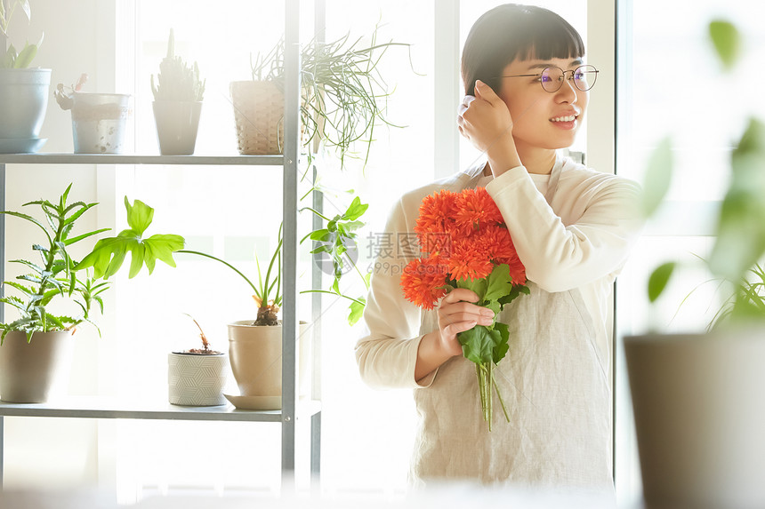 家庭主妇在家手拿着鲜花图片