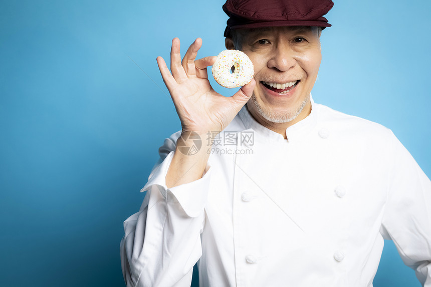 老年人厨师开心拿着甜甜圈图片