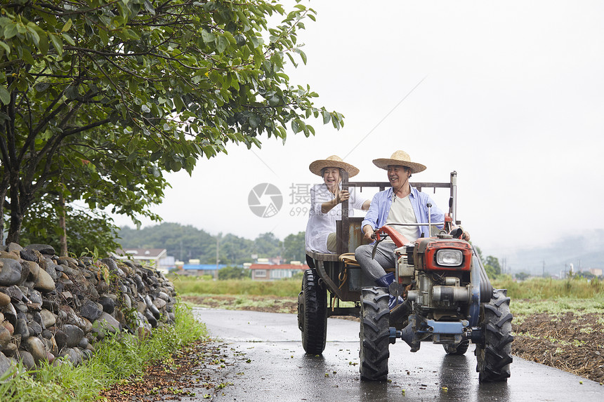 老年夫妇驾乘拖拉机下农田图片