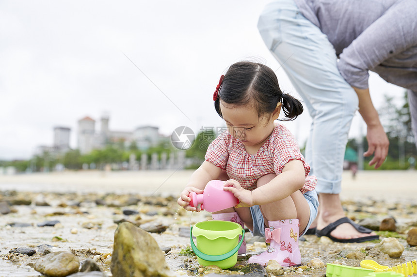 在海边捡石子的一家人图片