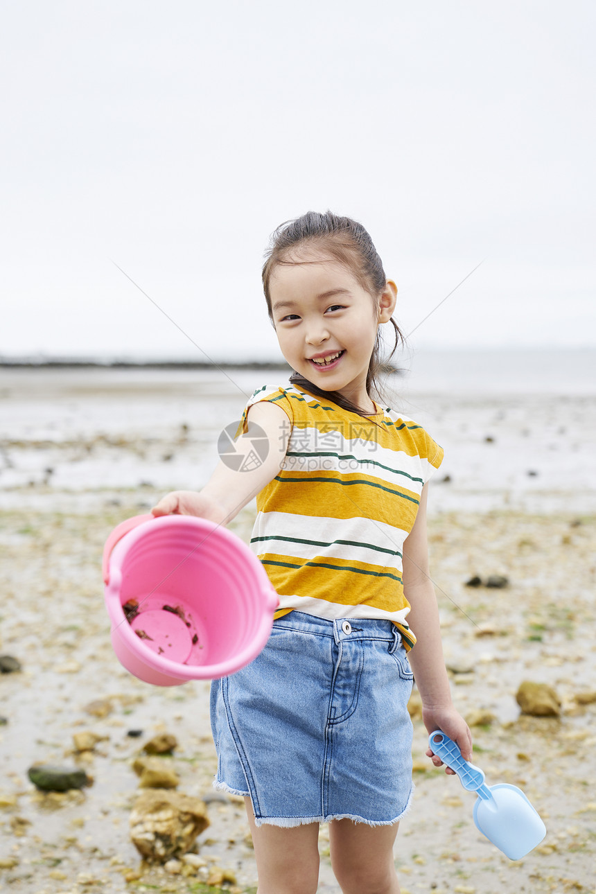 在海边捡石子的小女孩图片