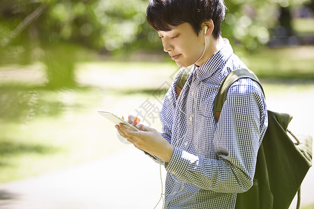 低头看着手机的青年男子图片