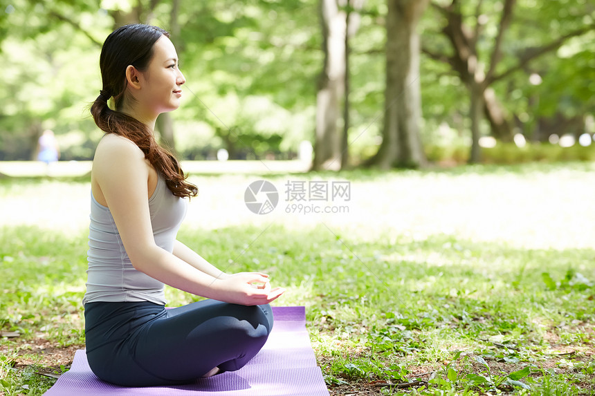 公园里坐在瑜伽垫上的女子图片