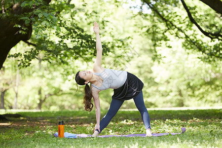 草地公园做瑜伽的女青年图片