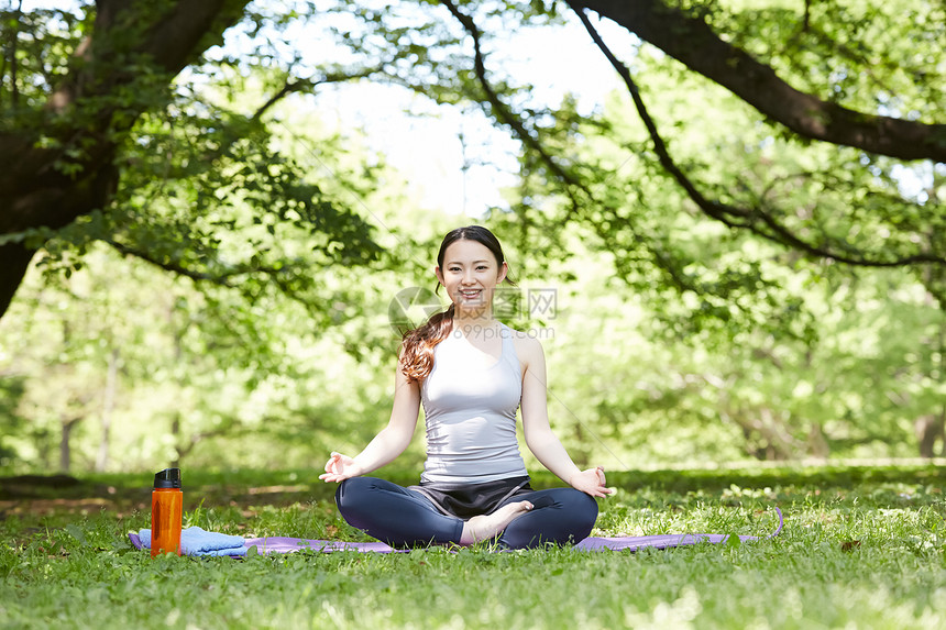公园草坪上做瑜伽的女子图片