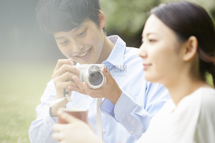 公园里男子拿着相机拍女朋友图片