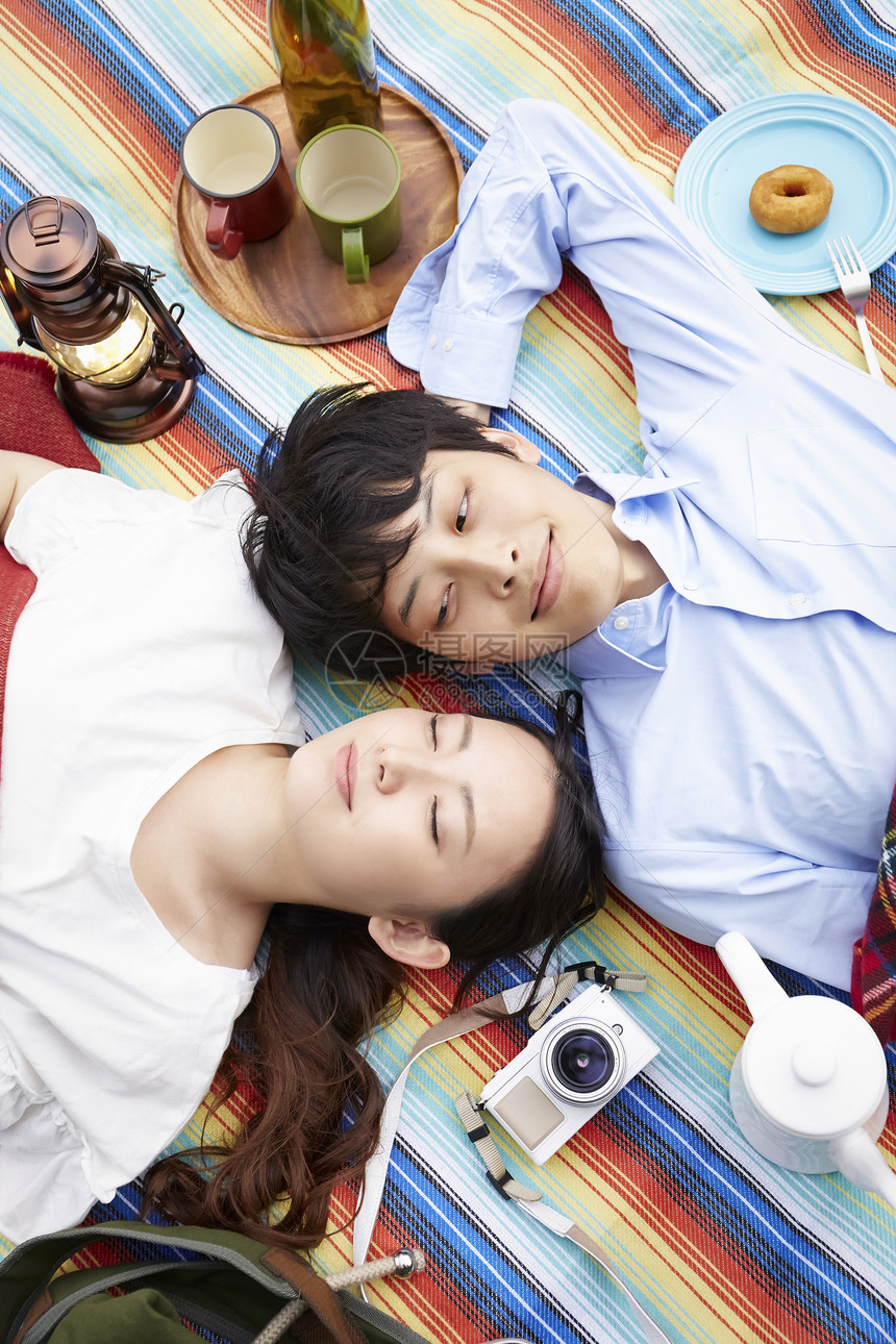 躺在野餐垫上休息放松的夫妇图片