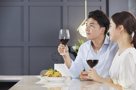 年轻夫妻吃西餐喝红酒背景图片