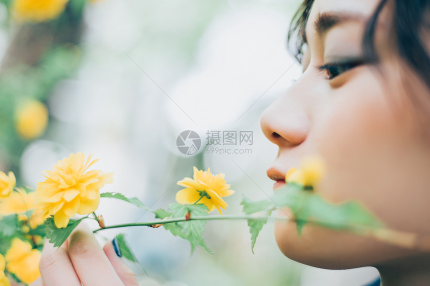 小姑娘户外看着花图片