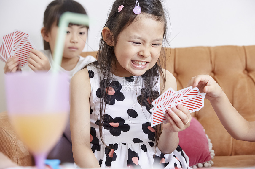 室内玩耍女孩和朋友一起玩卡片图片